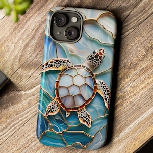 May include: A smartphone case featuring a sea turtle design. The case has a stained glass effect with shades of blue, white, and brown. The turtle is centered on the case, with a detailed shell and flippers. The case is on a wooden surface.