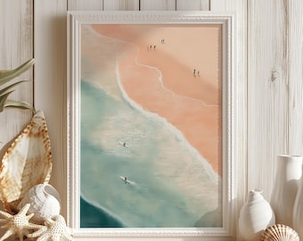 May include: A framed beach scene print with a white frame. The artwork depicts a beach with people and surfers in the water. The color palette includes shades of pink, blue, and white. Decorative seashells and vases are on a wooden shelf.