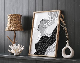 Könnte beinhalten: Ein gerahmter Schwarz-Weiß-Kunstdruck mit dem Profil einer Frau mit fließendem Haar. Das Kunstwerk befindet sich in einem Holzrahmen und lehnt an einer dunkelgrauen Wand. Eine gewebte Lampe, Korallen und eine weiße Vase mit getrockneten Pflanzen sind ebenfalls zu sehen.