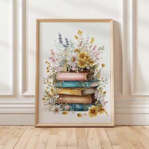Puede incluir: Una impresión en acuarela enmarcada que presenta una pila de libros adornada con un vibrante arreglo floral. Los libros tienen cubiertas coloridas en tonos rosa, turquesa y dorado. Las flores incluyen margaritas, flores amarillas y lavanda.