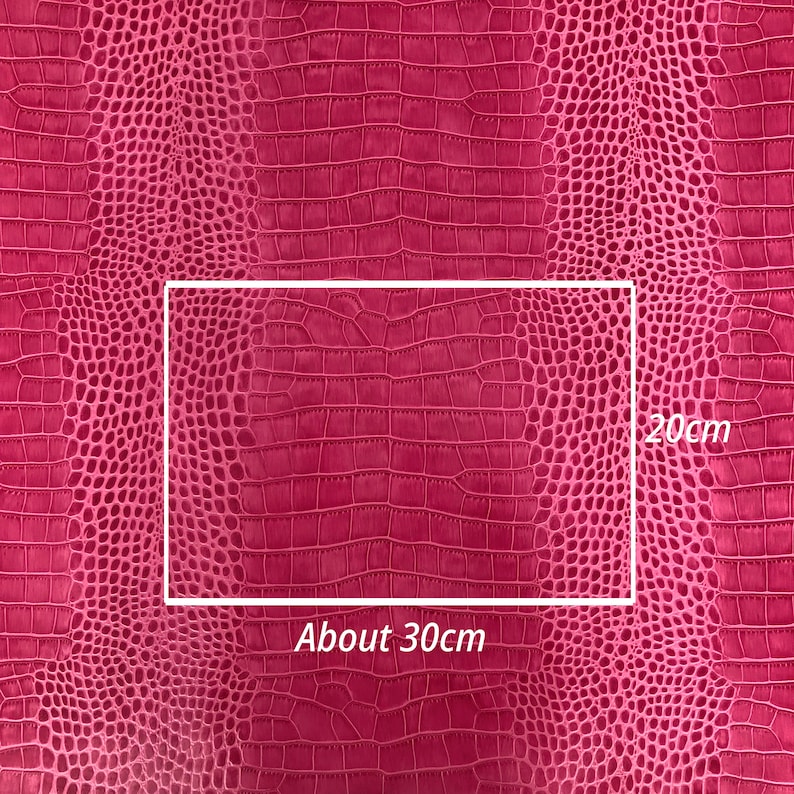 May include: Close-up of a pink crocodile-embossed fabric with a rectangular section highlighted. The fabric measures approximately 30cm by 20cm.