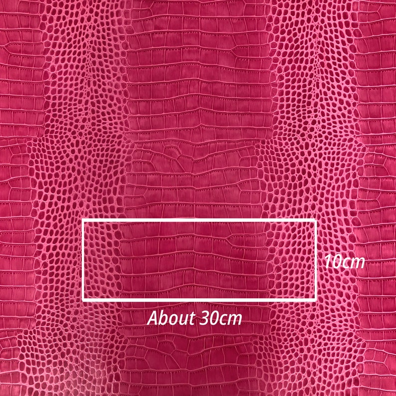 May include: Pink faux crocodile embossed fabric with a textured pattern. The fabric is approximately 30 inches wide and 10 inches tall.