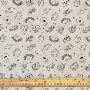 May include: White fabric with a black and white repeating pattern of Star Wars characters, including Darth Vader, Princess Leia, Chewbacca, and Stormtroopers. The fabric also features the words "Star Wars" repeated throughout the pattern.