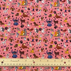 May include: Pink fabric with a repeating pattern of cartoon dogs, paw prints, and bones. Stitch from Lilo & Stitch is also featured in the pattern.
