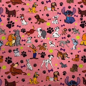 May include: Pink fabric with a repeating pattern of cartoon dogs and paw prints. The dogs are from various Disney movies, including Lady and the Tramp, 101 Dalmatians, and Stitch.