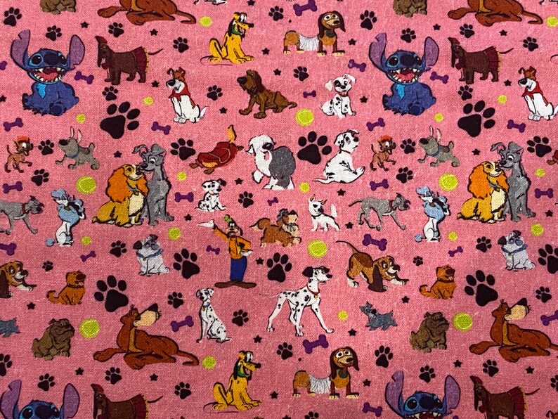 May include: Pink fabric with a repeating pattern of cartoon dogs and paw prints. The dogs are from various Disney movies, including Lady and the Tramp, 101 Dalmatians, and Stitch.