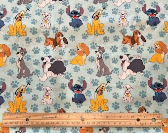 May include: A blue and white fabric with a repeating pattern of paw prints and cartoon dogs. The dogs include Stitch, Lady, Tramp, and Pluto.