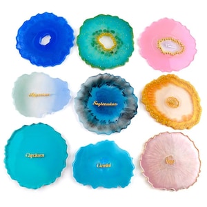 May include: Nine resin coasters with a geode design in various colors, including blue, green, pink, and gold. Each coaster features a gold inscription with a zodiac sign: Aquarius, Sagittarius, Capricorn, Gemini, Virgo.