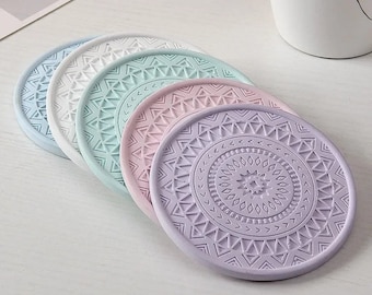 May include: Set of six round coasters with a geometric pattern. The coasters are in shades of purple, pink, blue, and white.