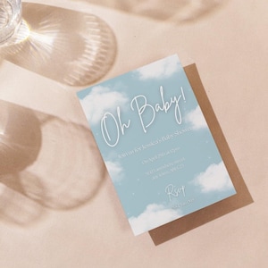 May include: A blue baby shower invitation with white clouds and stars. The text reads "Oh Baby!" and includes details for the event, such as the date, time, and location. RSVP information is also included.