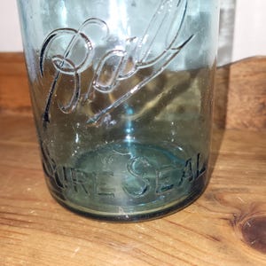 May include: A vintage blue glass Ball jar with the text "PURE SEAL" embossed on the bottom.