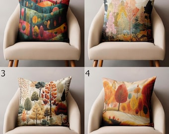 Puede incluir: Cuatro cojines decorativos con diseños de paisajes. Cada cojín presenta una representación artística diferente de árboles y follaje en varios colores, incluyendo verdes, naranjas y rojos. Los cojines se exhiben en sillas beige.
