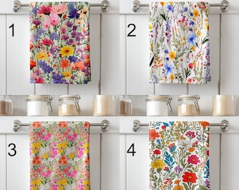 May include: Four rectangular kitchen towels hanging on a metal rack, each featuring a distinct colourful wildflower pattern. Towel 1 has dense mixed blooms, 2 has delicate stems, 3 has small pink and yellow flowers, and 4 has bold floral illustrations.