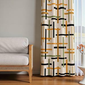 Può includere: Tenda color crema con un motivo geometrico di linee intersecanti in nero, verde oliva e arancione. La tenda è appesa accanto a una finestra e a un divano chiaro con braccioli in legno.