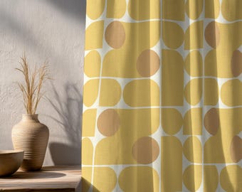 May include: Yellow and white patterned curtain with a mid-century modern design. The curtain features a repeating pattern of rounded shapes in yellow and peach, outlined with white lines. The curtain is hanging in front of a white wall.