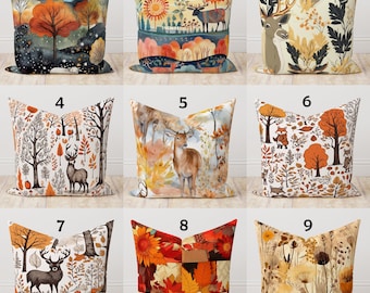 May include: A collection of nine decorative throw pillows with autumn-themed designs. The pillows feature various illustrations, including deer, trees, and fall foliage in shades of orange, brown, and beige. Each pillow has a unique design, perfect for seasonal home decor.