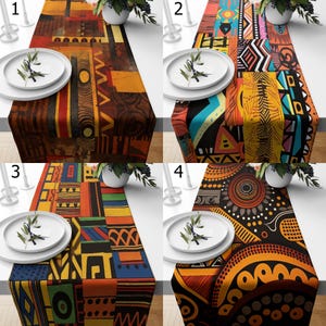 Op de afbeelding: Vier tafellopers met verschillende geometrische en abstracte patronen. Ontwerp één heeft bruine en oranje tinten. Ontwerp twee toont levendige veelkleurige vormen. Ontwerp drie toont een raster van primaire kleuren. Ontwerp vier heeft zwarte en oranje cirkelvormige motieven.