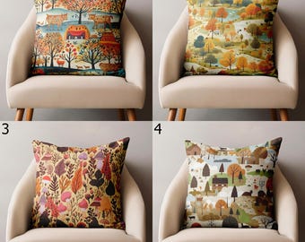 May include: Four decorative throw pillows with colorful autumn landscape designs. Each pillow features a different pattern, including trees, houses, and animals. The pillows are displayed on beige chairs.