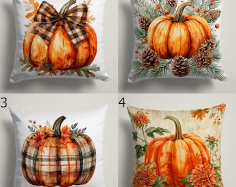 May include: Four decorative throw pillows with watercolor pumpkin designs. Each pillow features a different pumpkin design, including pumpkins with plaid patterns, bows, and floral accents. The pillows are square and have a white background.