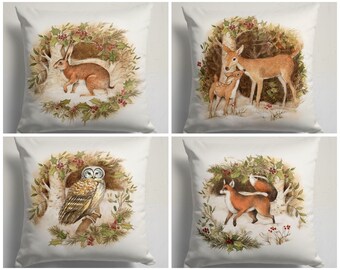 May include: Set of four white throw pillow covers with a winter woodland theme. Each pillow features a different animal: a rabbit, a deer, an owl, and a fox. The animals are surrounded by holly and berries.