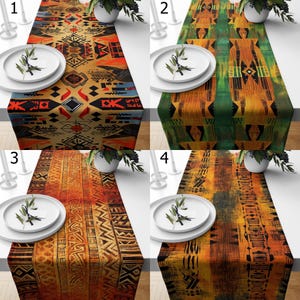 Puede incluir: Se muestran cuatro caminos de mesa con estampados étnicos. Cada camino de mesa presenta un diseño único en tonos naranja, marrón, verde y negro. Los caminos de mesa son rectangulares y están colocados sobre una superficie blanca, con platos y elementos decorativos.
