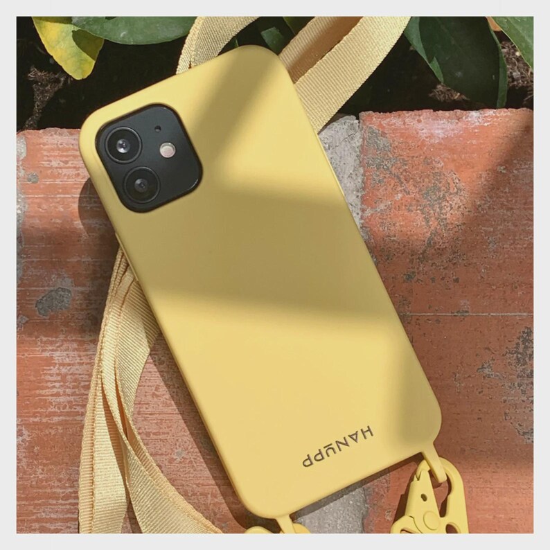 May include: A yellow phone case with a matching strap. The case has a dual-lens camera cutout and the word "HANYPP" printed on the lower right. The strap is attached to the case with a small, yellow clasp.