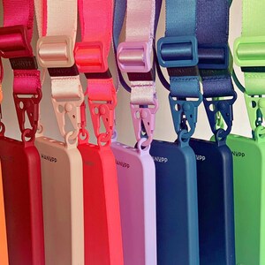 May include: A collection of colorful phone cases with matching lanyards. The cases are in shades of yellow, orange, red, pink, purple, blue, and green. Each case has a lanyard with a matching color. The cases have the word "NVPP" printed on them.