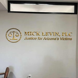 3D logo wall sign made with polished or brushed metal for a custom lobby sign in stainless metal on a dark wall in a modern conference room