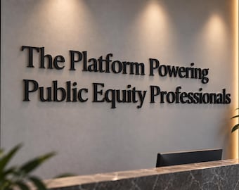 Könnte beinhalten: Ein Wandschild mit schwarzen, dreidimensionalen Buchstaben, die den Text, The Platform Powering Public Equity Professionals, bilden. Das Schild befindet sich an einer hellgrauen Wand über einem Empfangstresen aus dunkelgrauem Marmor mit einer Pflanze.