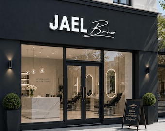 Pode incluir: Vista exterior de um moderno salão de beleza, "JAEL Brow", com fachada preta e grandes janelas de vidro. A placa acima da entrada é branca. Uma placa em forma de A diz "Brows Beauty Confidence Redefined". O interior apresenta um balcão de mármore e cadeiras de salão.