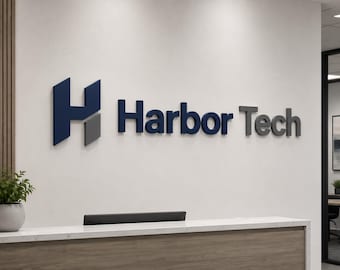 Pode incluir: O logotipo da Harbor Tech é exibido em uma parede branca. O logotipo apresenta um "H" estilizado em azul e cinza, seguido das palavras "Harbor Tech" em azul e cinza. Uma recepção e uma planta em vaso estão em primeiro plano.