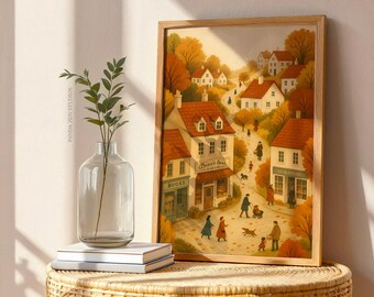 Puede incluir: Una impresión artística enmarcada representa una encantadora escena de pueblo con edificios, personas y árboles en colores otoñales. La obra de arte presenta una paleta de colores cálidos y un marco de madera. La impresión se exhibe sobre una mesa tejida.