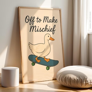 May include: A framed print with a cartoon duck on a skateboard. The duck is cream-coloured with an orange beak and feet. The skateboard is teal with green wheels. The text "Off to Make Mischief" is above the duck.
