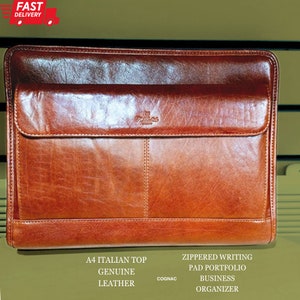 May include: A brown leather A4 Italian top zippered writing pad portfolio business organiser with the word "COGNAC" printed on the front.