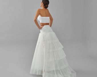 May include: A white tulle petticoat with multiple layers, designed to add volume and shape to a skirt or dress.