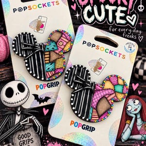 Puede incluir: Dos accesorios para teléfono PopSockets PopGrip en tarjetas holográficas. Cada uno presenta un diseño con forma de Mickey Mouse dividido entre un patrón de rayas blancas y negras y un patrón de retazos colorido y texturizado con pedrería.