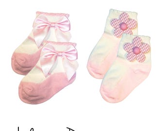 May include: Two pairs of baby socks. One pair is pink and white with a pink satin bow. The other pair is pink and white with a pink gingham flower.
