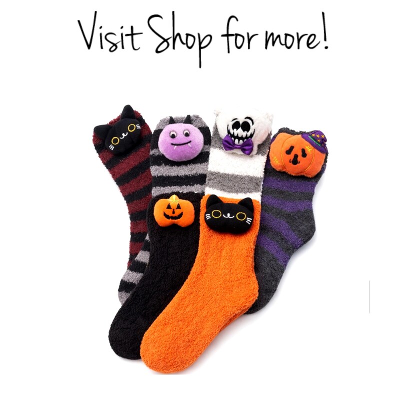 May include: A collection of Halloween-themed fuzzy socks. Each sock features a different character: a black cat, a purple bug, a skull, and a pumpkin. The socks are in various colors, including orange, black, and purple, with striped and solid patterns. Text reads: Visit Shop for more!