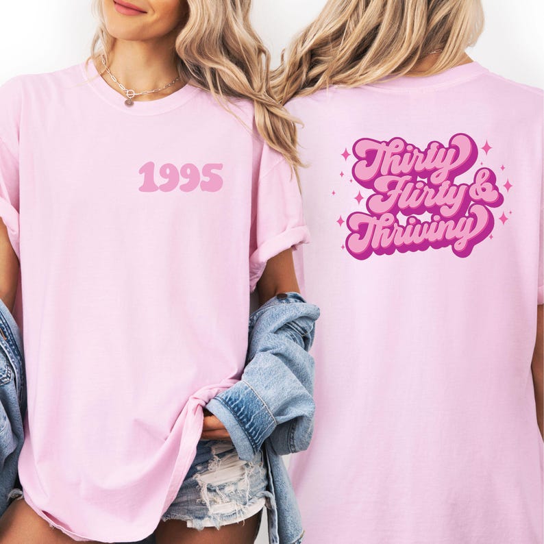 May include: Light pink t-shirts with the text "1995" on the front and "Thirty, Flirty & Thriving" on the back in a retro font. The shirts are a soft pink color.