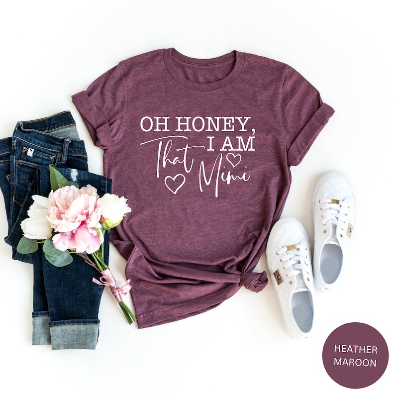 May include: A heather maroon t-shirt with the text "Oh honey, that I am Mimi" in white with three white hearts.