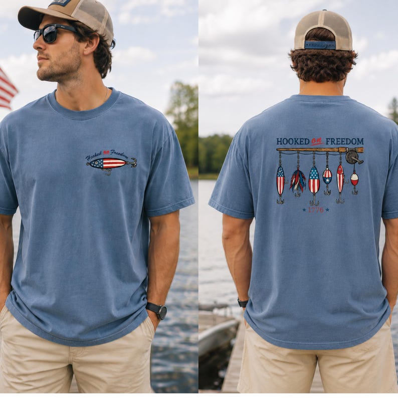 May include: Blue short-sleeved t-shirt with "Hooked on Freedom" text and fishing lure graphics. The front features a small lure design, while the back displays a fishing rod with patriotic lures and the year "1776".