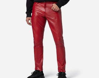 Può includere: Pantaloni in pelle rossa con un classico design a cinque tasche. I pantaloni hanno una vestibilità slim. Il modello indossa scarpe da ginnastica nere. I pantaloni sono realizzati in pelle liscia e lucida. I pantaloni sono lunghi circa 100 cm.