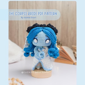 May include: A crochet pattern for a blue and white amigurumi doll of the Corpse Bride, with a black flower crown and a white rose. The pattern is available as a PDF download. The text "THE CORPSE BRIDE PDF PATTERN" and "By Cuckoo Craft" is visible in the image.