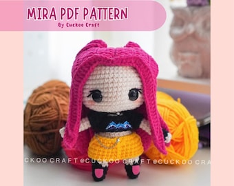 May include: A handmade crochet doll with a white face, black eyes, and bright pink hair. The doll wears a black top, yellow shorts, and black shoes. The text "MIRA PDF PATTERN" is displayed above the doll.