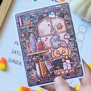 May include: A sticker featuring a whimsical illustration of a witch's cauldron with a pumpkin lid, surrounded by books, bottles, and ghosts. The background is a dark brick wall with stars and sparkles.