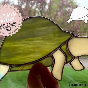 Op de afbeelding: Een gebrandschilderd schildpadpatroon in tinten groen en crème. Het patroon is alleen voor hobby- en kleinbedrijfgebruik. De artiestencredit is Dogwood Stained Glass.