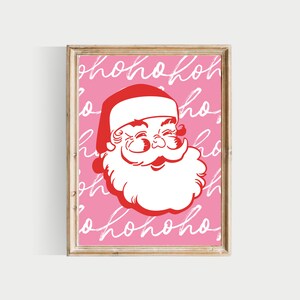 May include: A pink printable art print featuring a red and white illustration of Santa Claus's face. The background is filled with the words "ho ho ho" written in white.