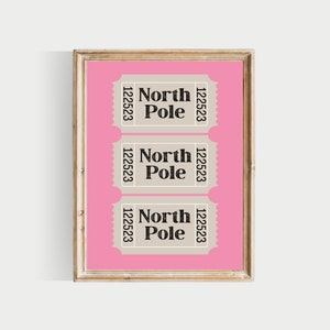 May include: Three beige ticket-shaped signs with black text on a pink background. Each sign reads "North Pole" with the number "122523" on either side. The signs are framed in a light wood frame.