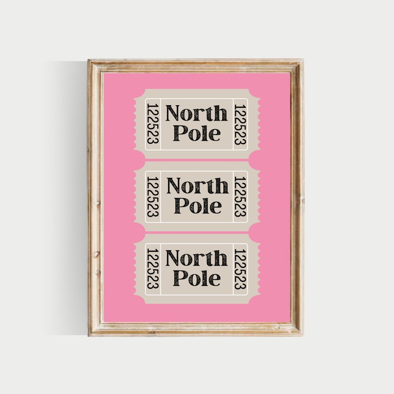 May include: Three beige ticket-shaped signs with black text on a pink background. Each sign reads "North Pole" with the number "122523" on either side. The signs are framed in a light wood frame.