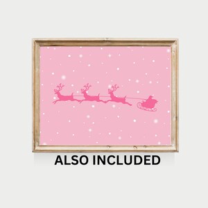 May include: Pink Christmas print featuring a silhouette of Santa Claus in a sleigh pulled by reindeer flying through a snowy sky.